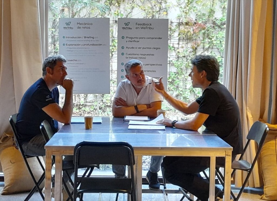 Tres miembros de WeTribu trabajan un reto en un encuentro