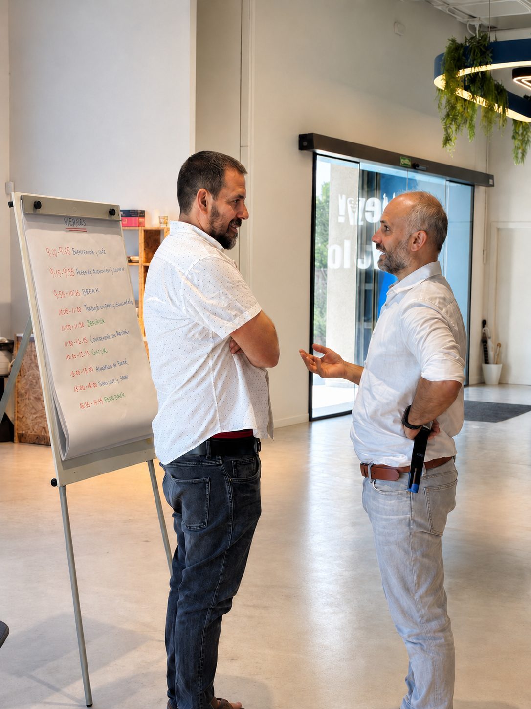 Dos miembros conversando junto al flipchart